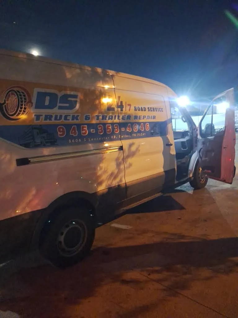 DS roadside service van beside a trailer at night