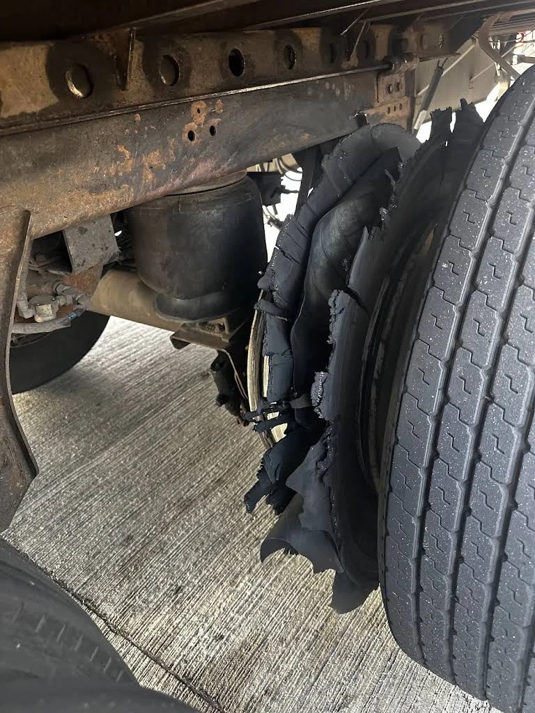 Damaged trailer tire beside its wheel