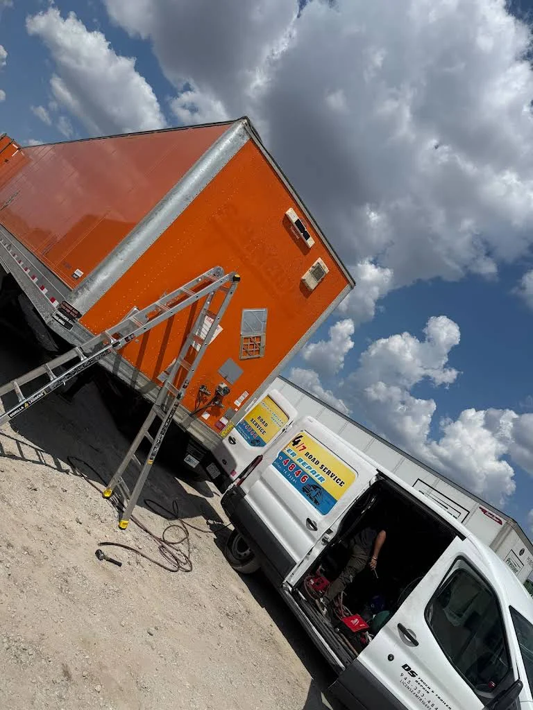 Orange semi truck with its hood raised